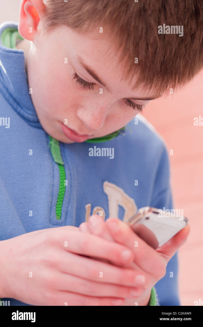Ein MODEL Release Bild eines elf Jahre alten Jungen mit seinem Ipod Touch im Innenbereich Stockfoto