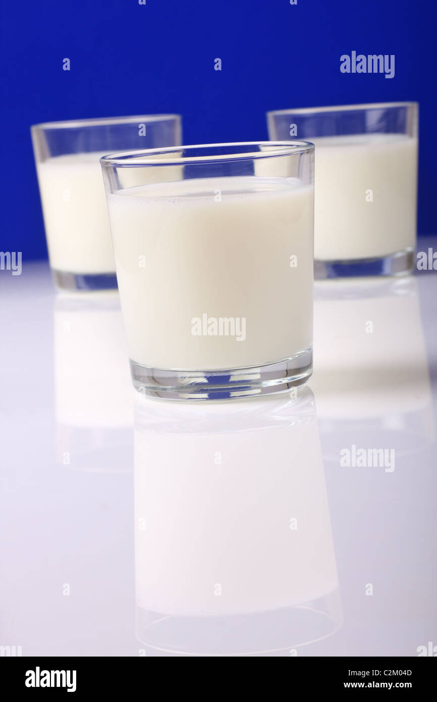 frische Gläser Milch auf reflektierende Oberfläche Stockfoto