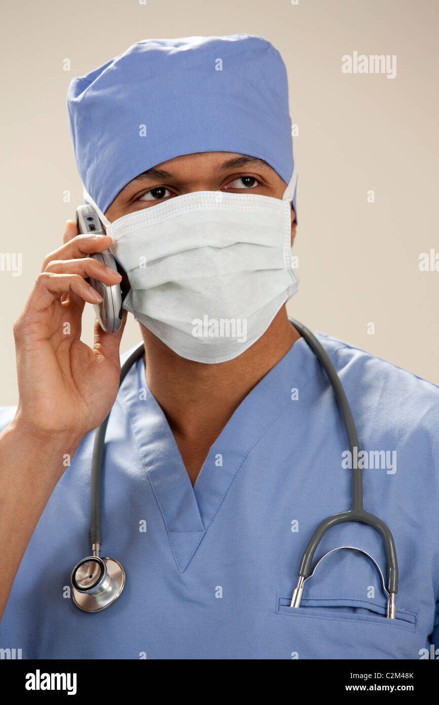 Afrikanische amerikanische Arzt in Peelings tragen Mundschutz auf dem Handy Stockfoto