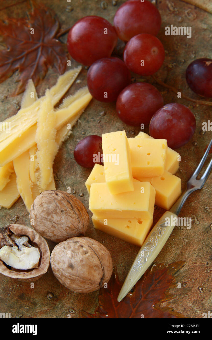 Käseplatte mit Trauben und Nüssen Stockfoto