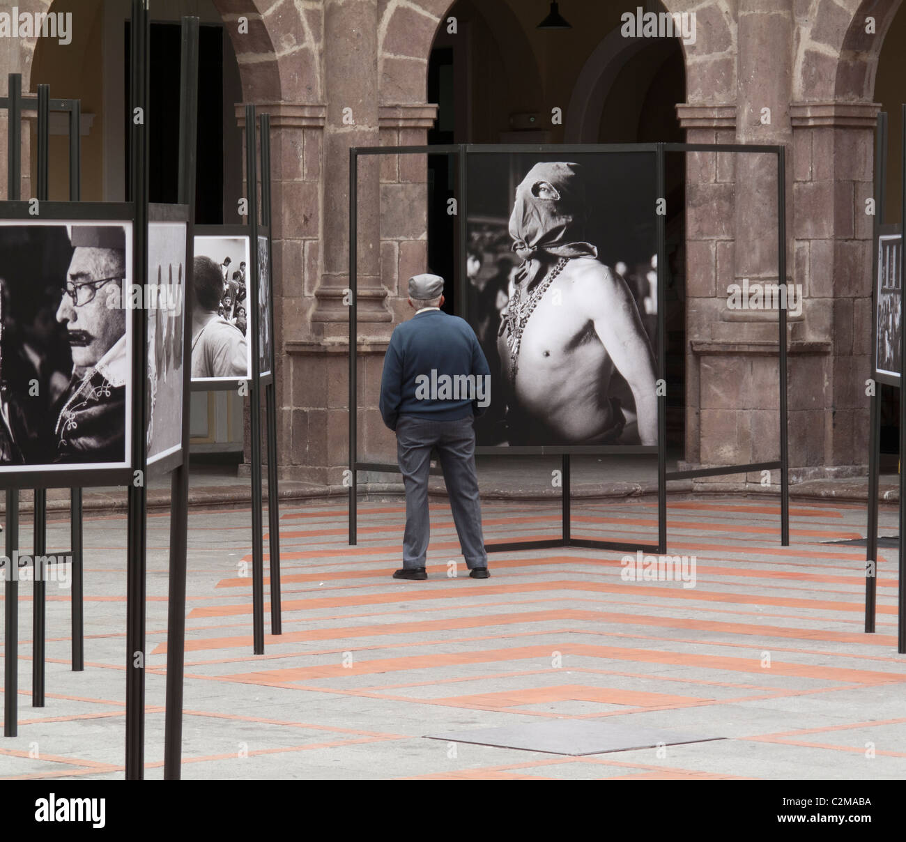 Mann auf der Suche auf Foto von vermummten Gestalt von religiöses fest, Ausstellung im Centro Cultural Metropolitano, Quito Stockfoto