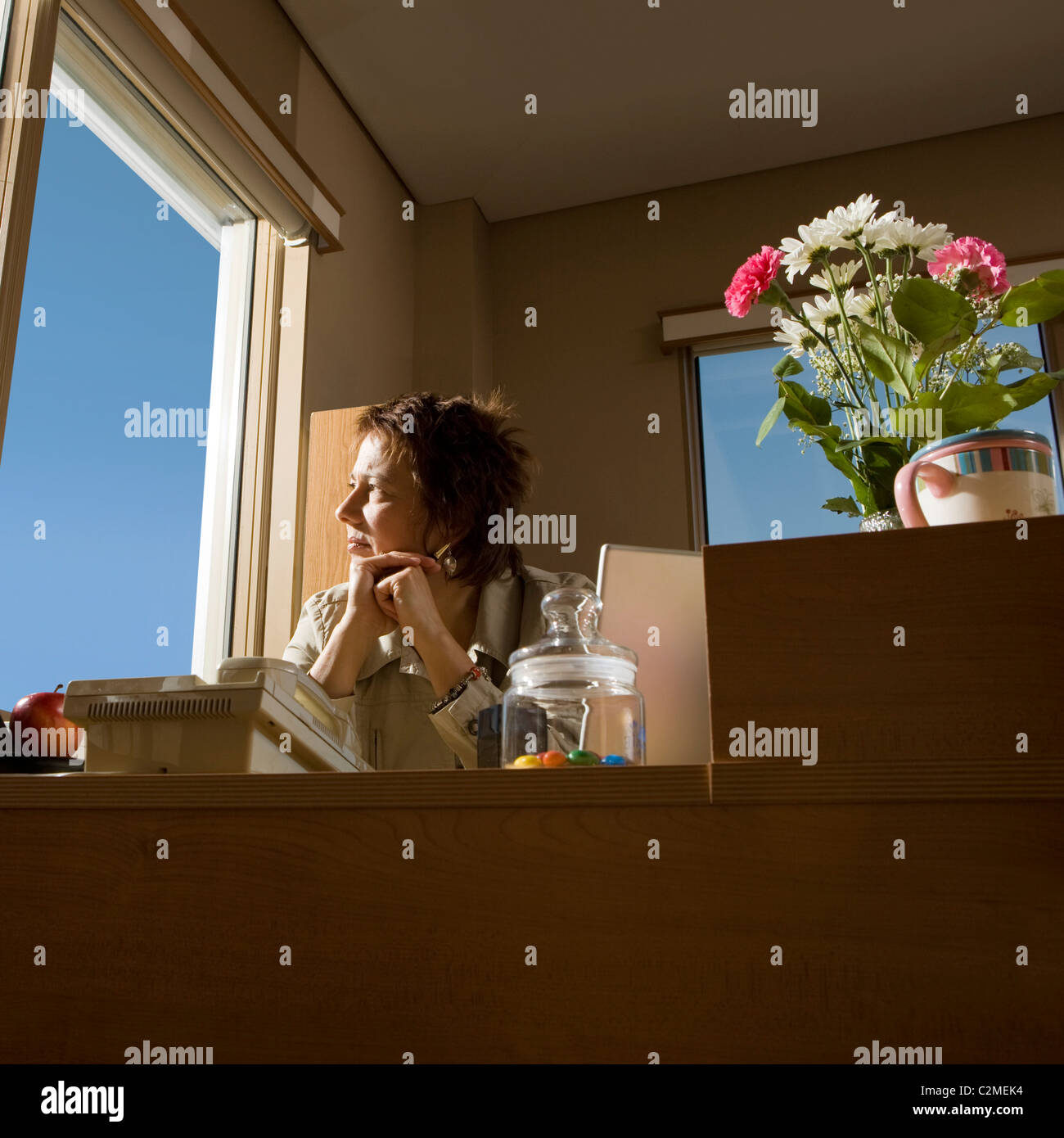 Geschäftsfrau im Amt; Frau schaut aus dem Fenster Stockfoto