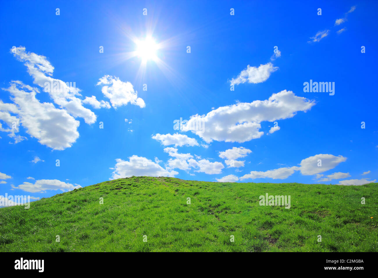 Grüne Grasberge unter Mittagssonne im blauen Himmel. Stockfoto