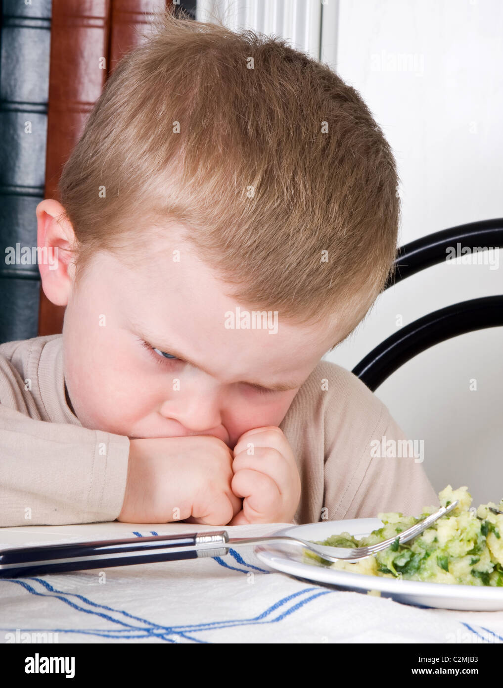 Vier Jahre alter Junge Abneigung das Essen auf seinem Teller Stockfoto
