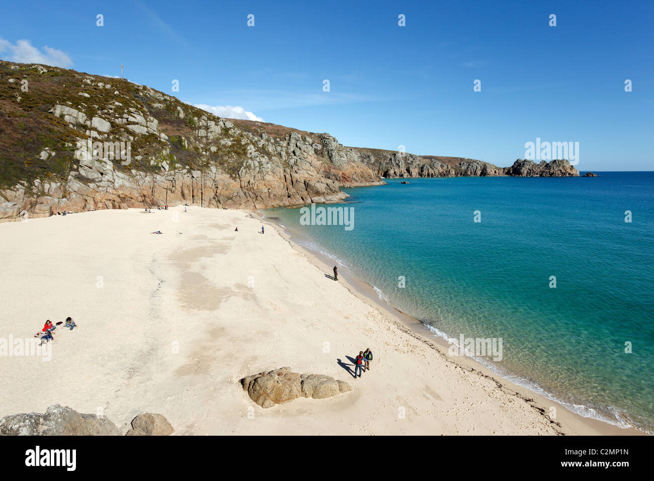 Porthcurno Strand und einem ruhigen türkisfarbenen Meer mit Logan Rock in der Ferne.  Cornwall UK. Stockfoto