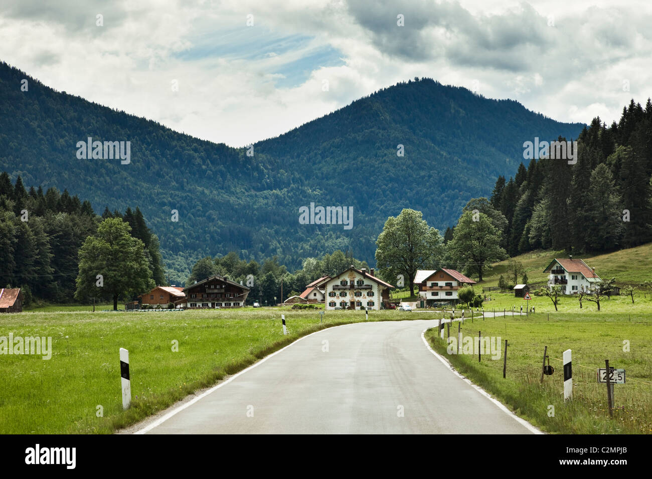 Straße durch ein kleines Dorf in Bad Tölz-Wolfratshausen, Bayern, Deutschland, Europa Stockfoto