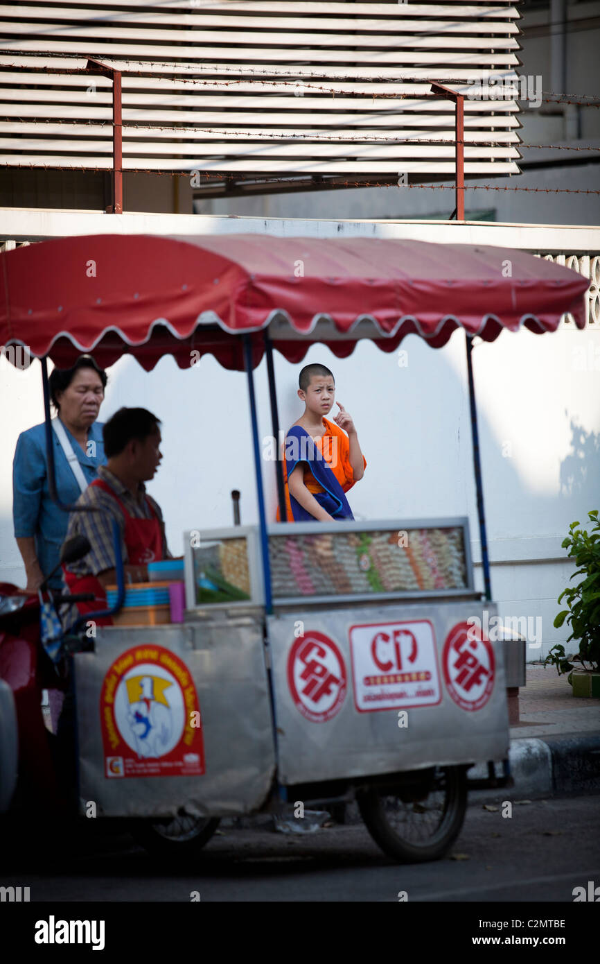 Junger Mönch wartet er ist Bus auf der Straße, mit Hersteller-Shop. Lampang, Thailand Stockfoto