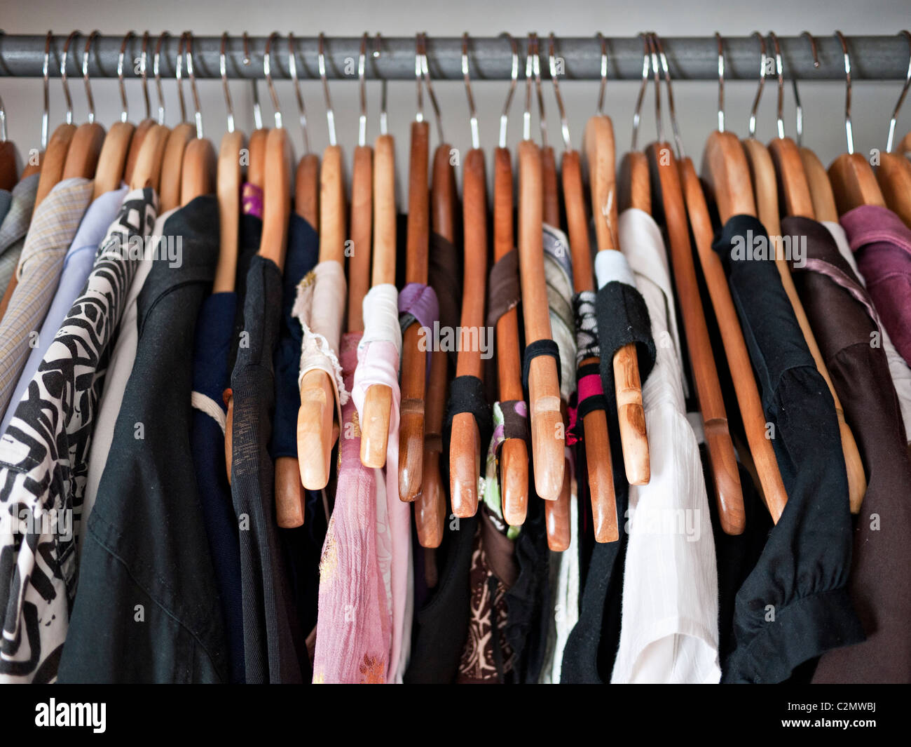 Kleiderstange im Schrank, Herren- und Damen Kleidung auf Holzbügel Stockfoto