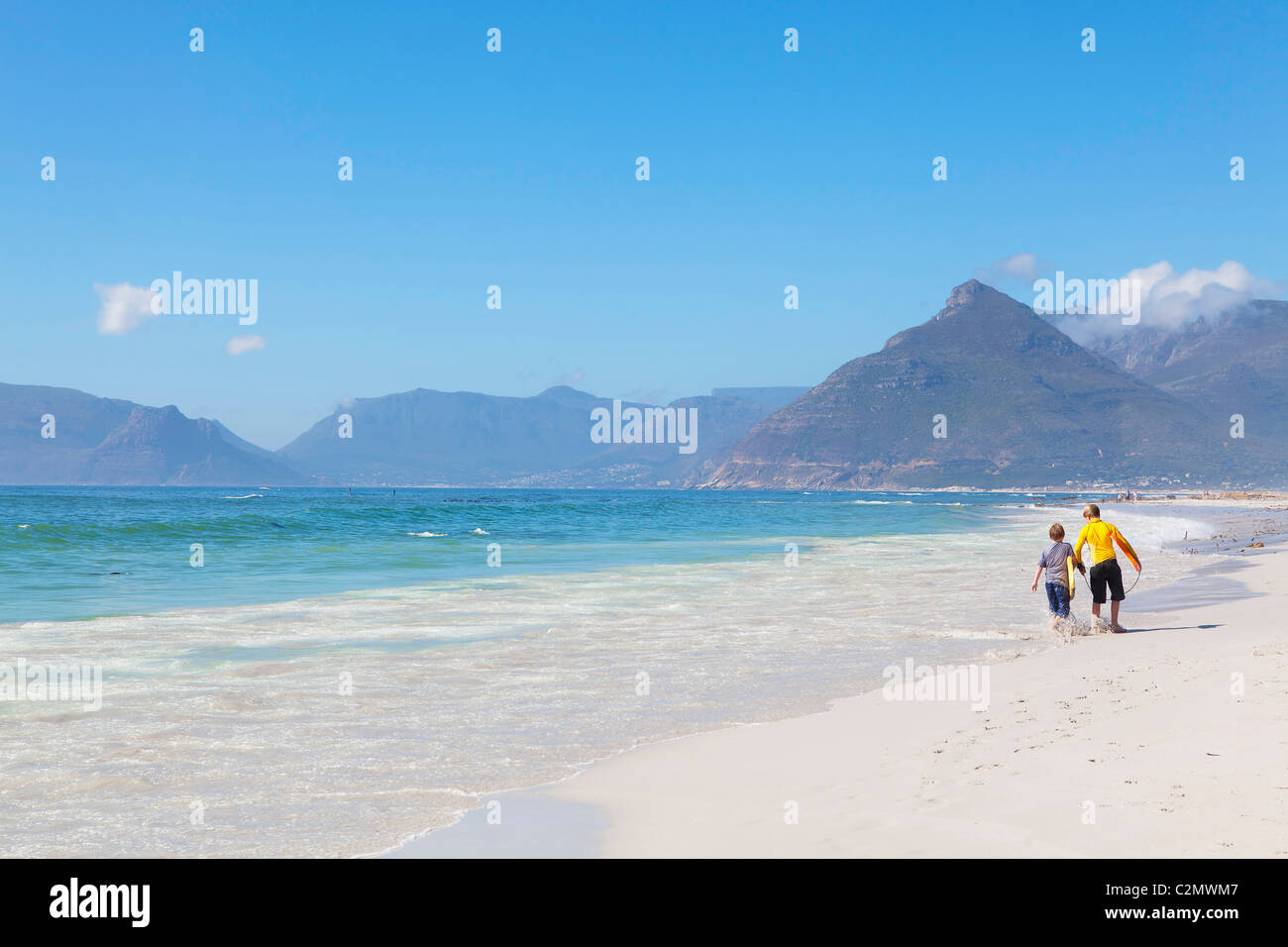 Surfen Partner aufstrebende junge Surfer, die ihren Weg zurück nach Hause nach verbringen einen Nachmittag in der Brandung am Strand von Noordhoek Stockfoto