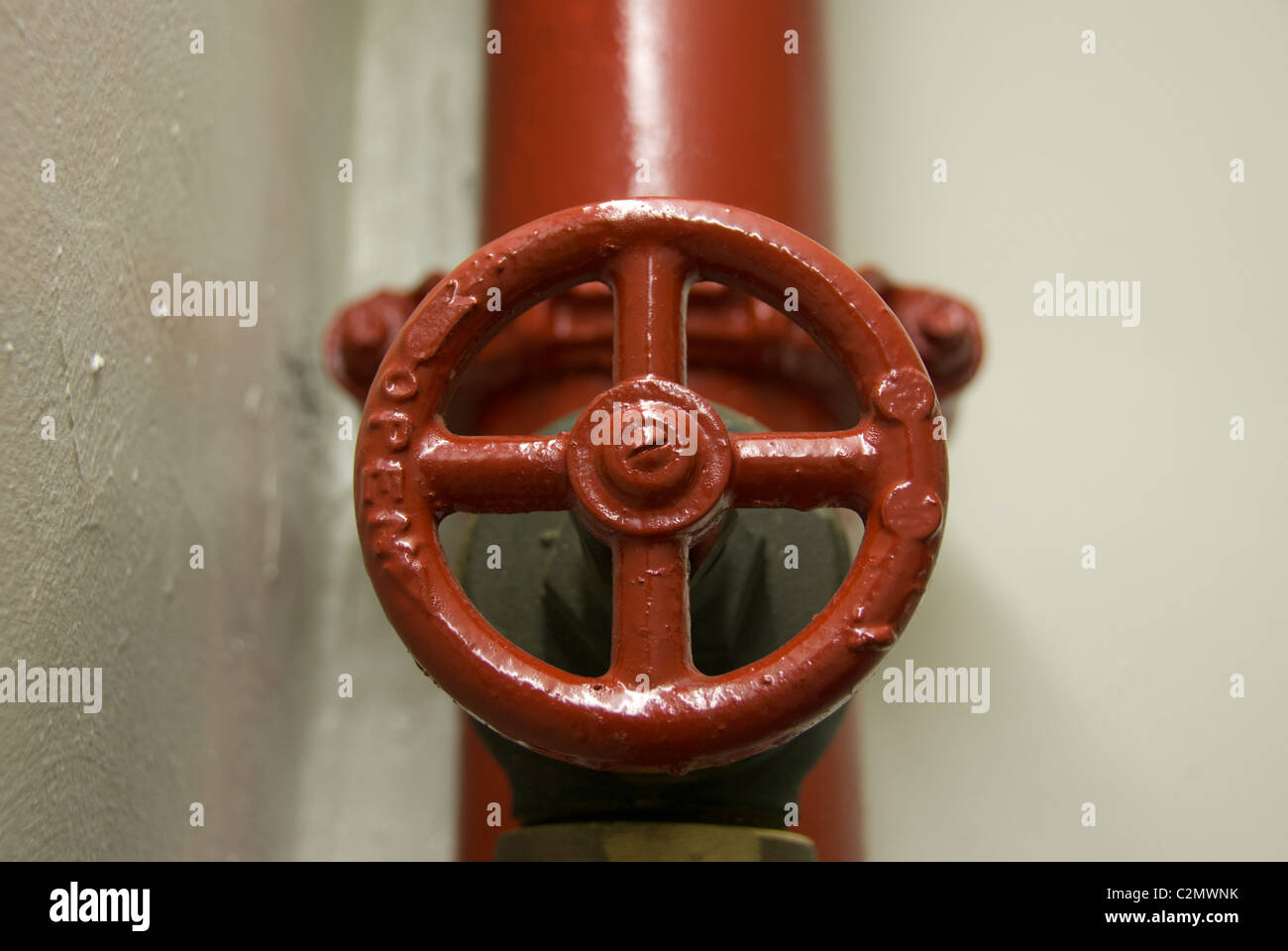 Ein rot lackiert kreisförmige Ventil im Brandschutzsystem Rohre von einem zivilen Gebäude Stockfoto