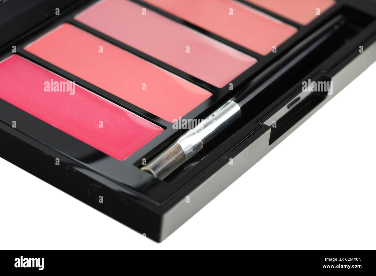 Lipgloss Palette mit Pinsel, Closeup auf weiß Stockfoto