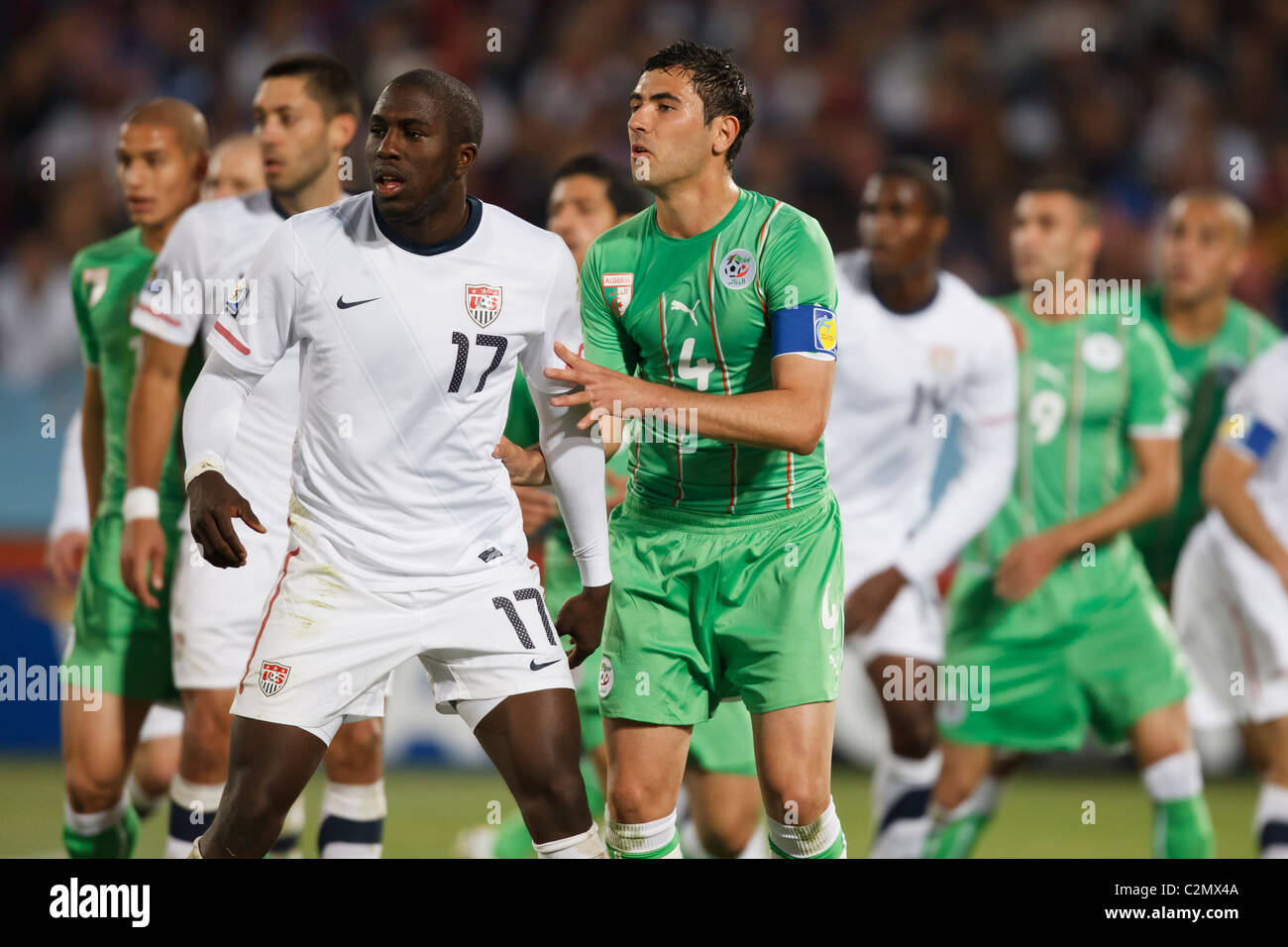 Jozy Altidore der USA (17) und Algerien Mannschaftskapitän Anther Yahia (4) erwarten einen Freistoß während des 2010 FIFA World Cup Spiels. Stockfoto