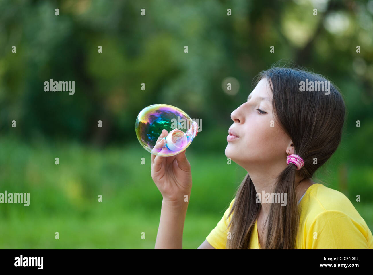 Junges Mädchen bläst Seifenblasen im park Stockfoto