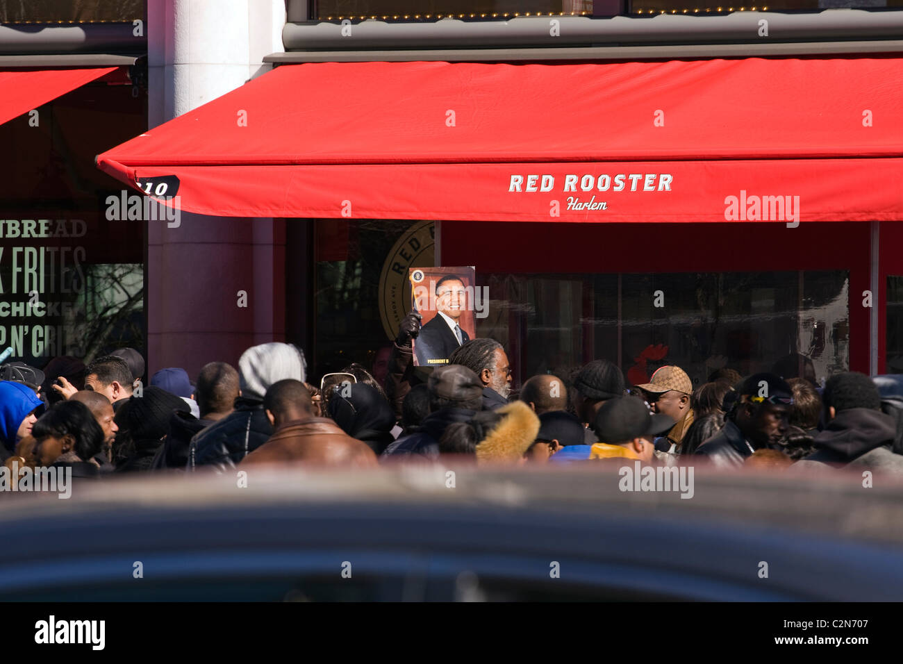 Dutzende von Harlem Bewohner vor dem Restaurant Roter Hahn in Harlem, New York City wartet auf Präsident Obama am 29.03.11 Stockfoto