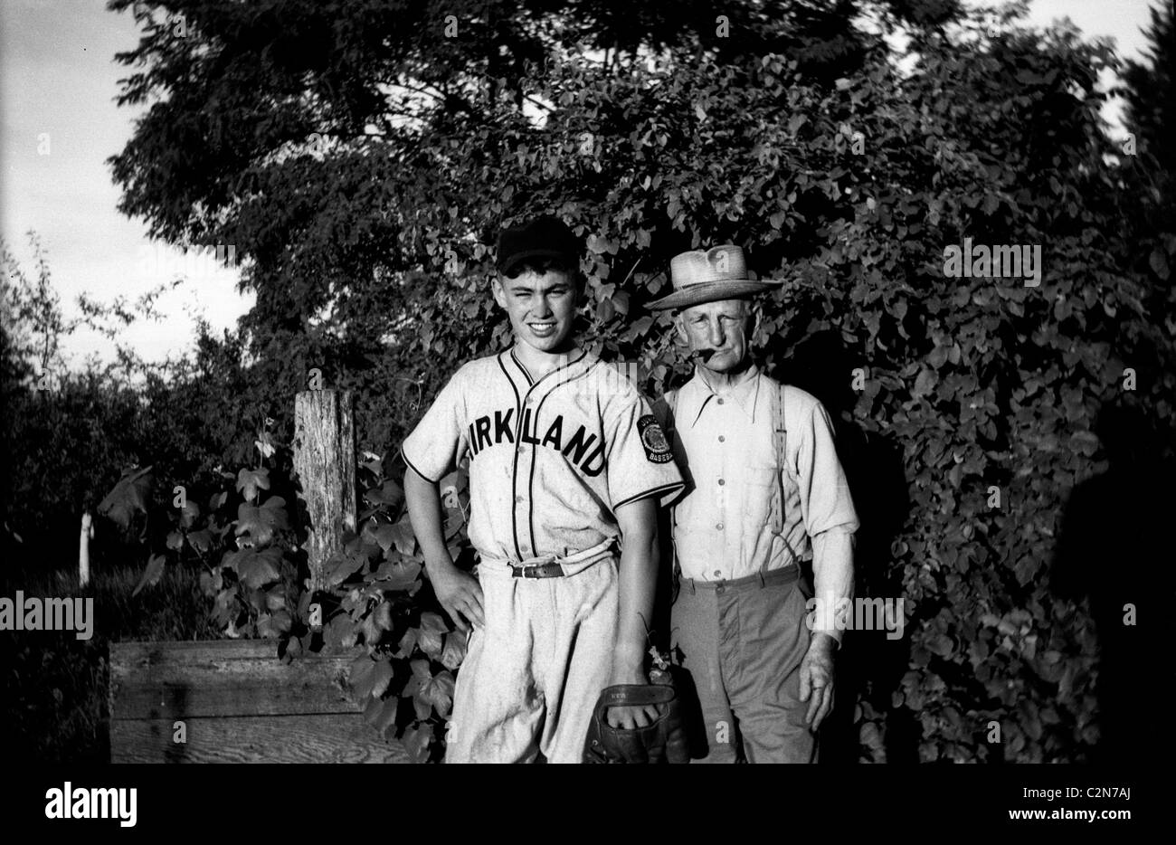 Ein Junge Baseballspieler und seinem Großvater in ein Foto in den 1940er Jahren. Stockfoto