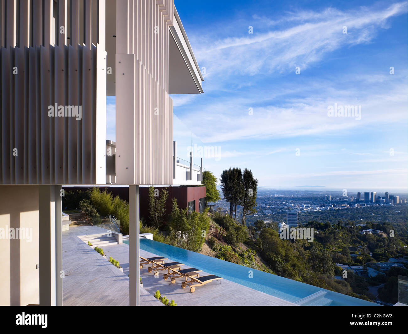 Modernes Einfamilienhaus, West Hollywood, Kalifornien. Blick auf Terrasse, Infinity Pool Tand Bäume in Los Angeles Becken. Stockfoto