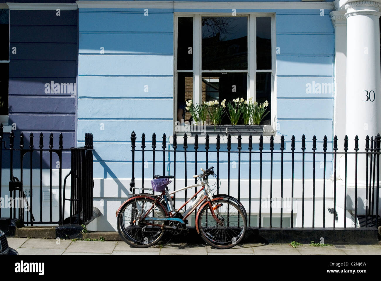 Fahrrad geparkt vor einem der bunten Terrassenhäuser Chalcot Square, in der Nähe von Primrose Hill, London, NW1, England Stockfoto