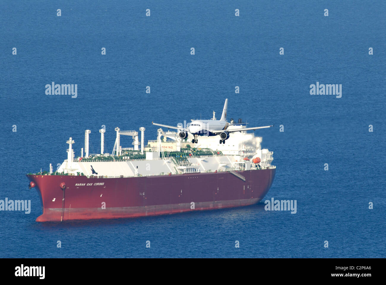 Monarch Airways engined Twin Jet Ansatz nach Gibraltar mit großen Tanker vor Anker in den Gewässern vor der Küste Stockfoto