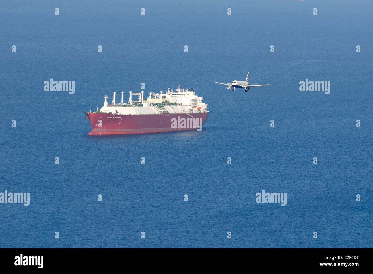 Monarch Airways engined Twin Jet Ansatz nach Gibraltar mit großen Tanker vor Anker in den Gewässern vor der Küste Stockfoto