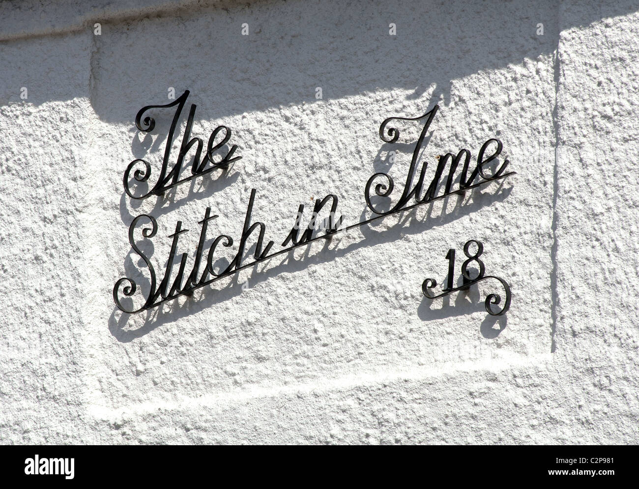 'Stitch in Time' Namen auf einem Haus Stockfoto
