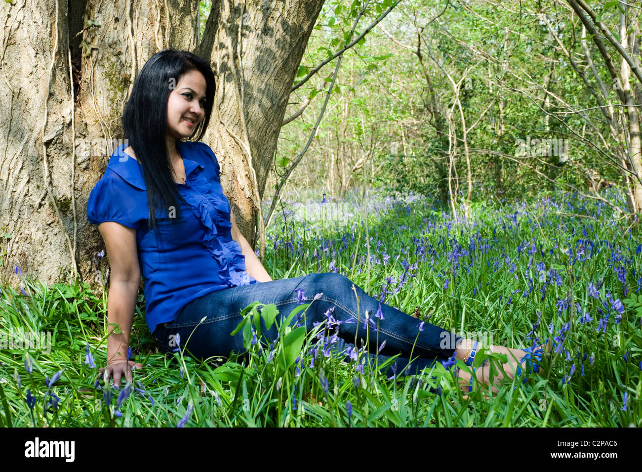 hübsche Frau, umgeben von Glockenblumen in Bere Wald england Stockfoto