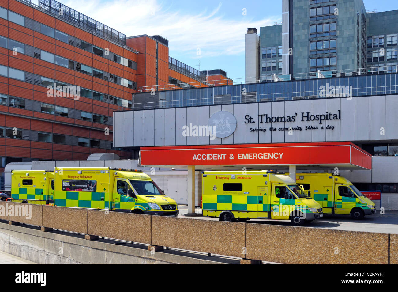 Unfall- und Notaufnahme beschäftigt mit Krankenwagen, die Patienten abliefern, die an der Drop-off-Bucht außerhalb des NHS St Thomas Hospital London England Großbritannien geparkt sind Stockfoto