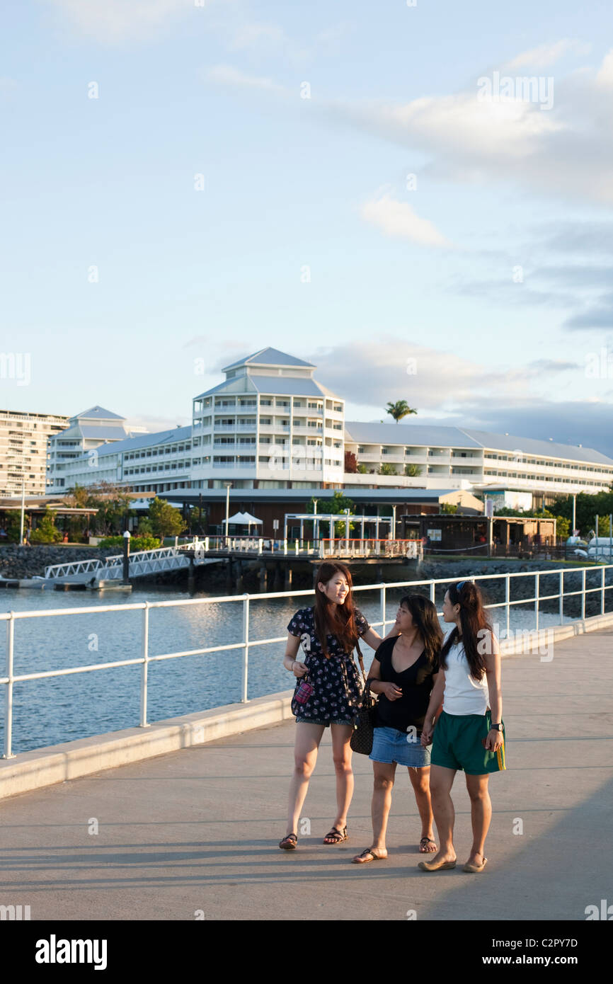 Touristen zu Fuß entlang Marlin Marina Steg mit Shangri-La Hotel im Hintergrund. Cairns, Queensland, Australien Stockfoto