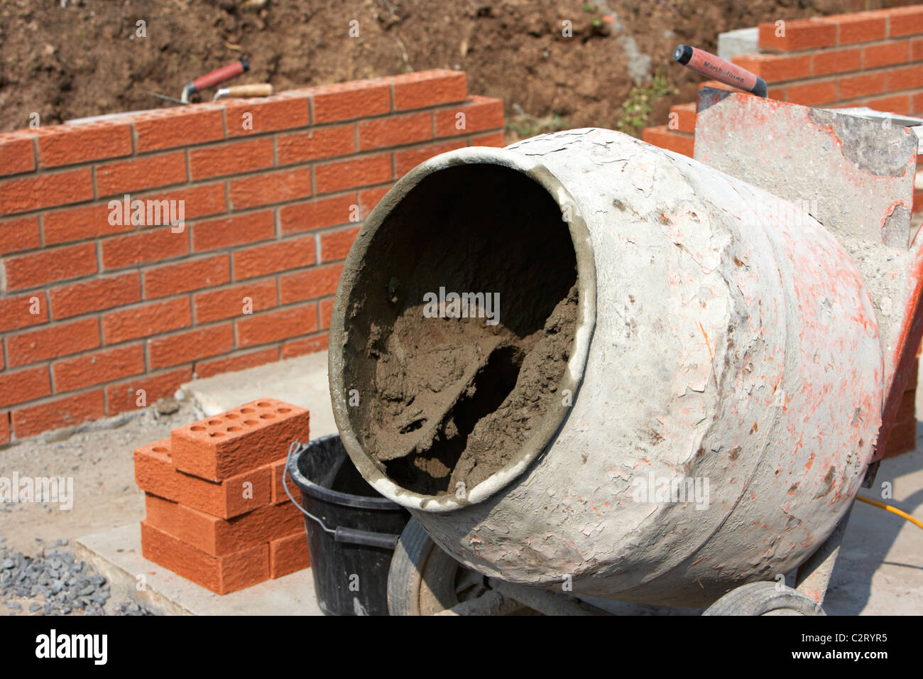 Zementmischer Mörtel verwendet für Maurerarbeiten Wand Bau einer Mauer in der uk-Bewegungen in mischenden Trommel Stockfoto