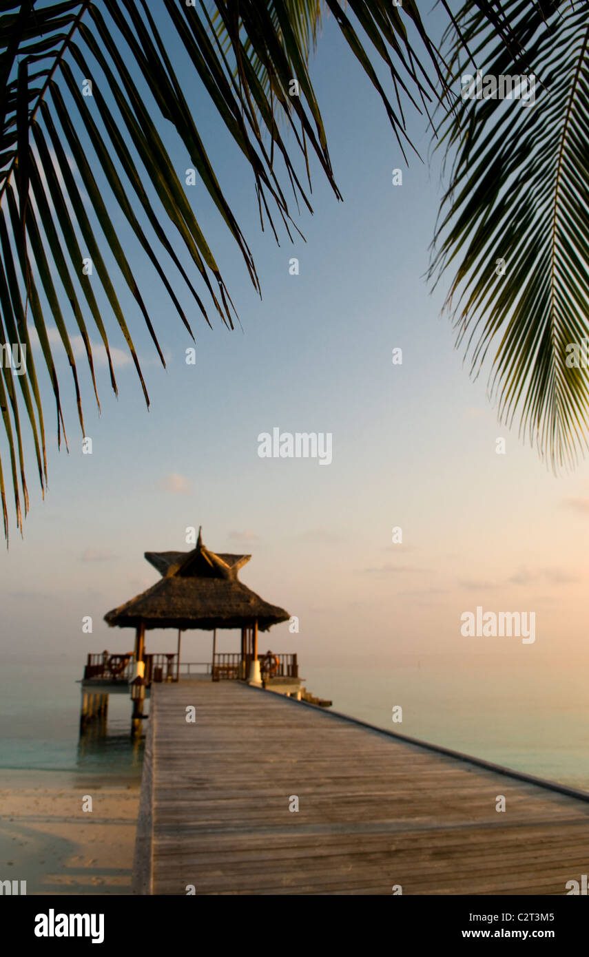 Pavillon und Steg mit Strohdach in einem Resort auf den Malediven Stockfoto