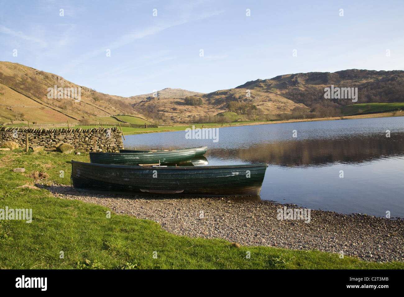 Lake District Cumbria England UK drei grüne Ruderboote festgemacht an der Seite des Watendlath Tarn Stockfoto