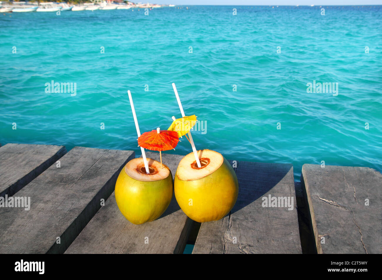 Kokosnuss Cocktails in Karibik auf hölzernen Pier türkisfarbenen Meer Stockfoto