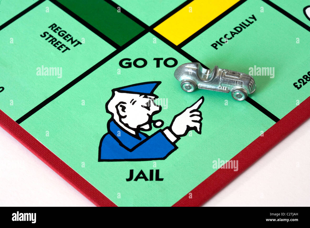 Schlechte Treiber; ein Auto auf dem 'Gehe zu Gefängnis' Raum auf ein Monopol Spielbrett UK Stockfoto
