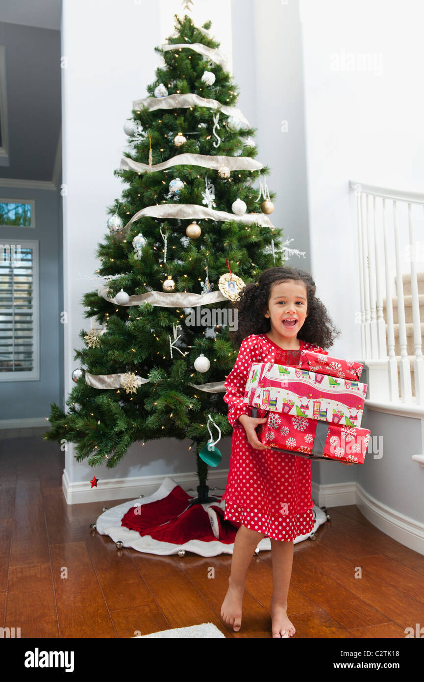Gemischte Rassen Mädchen halten Weihnachtsgeschenk Stockfoto