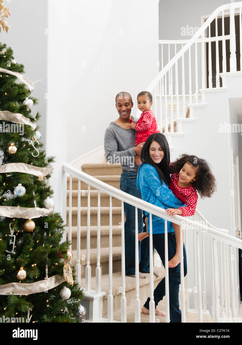 Familie absteigend Treppe am Weihnachtsmorgen Stockfoto