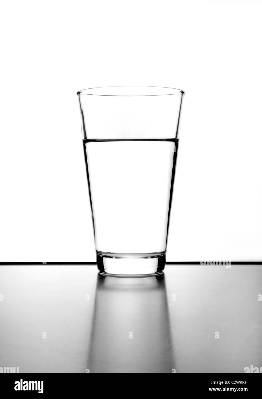 Glas fast voll mit Wasser, schwarz / weiß Foto Stockfoto