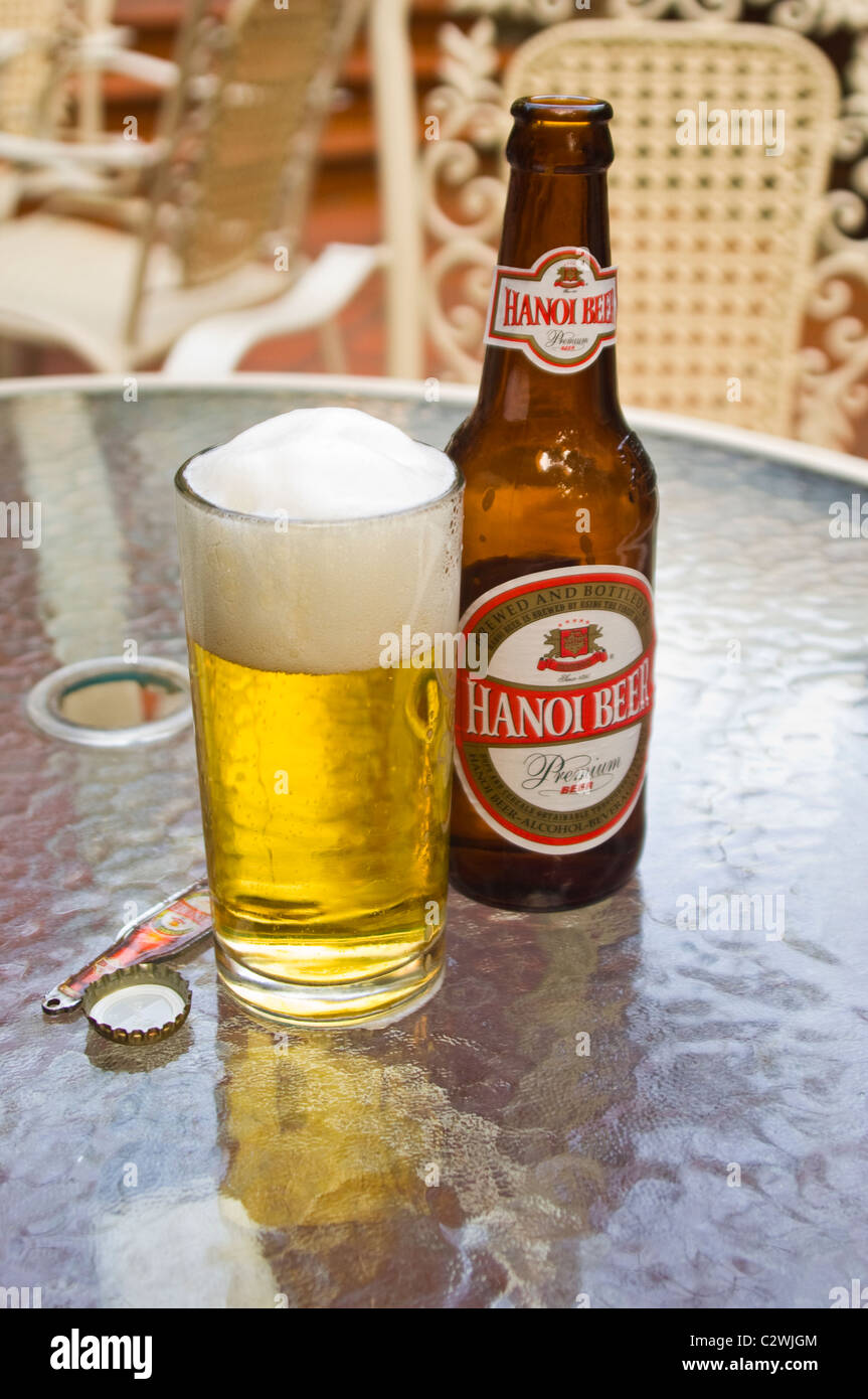 Vertikale hautnah ein volles Glas und Flasche Hanoi Bier auf einem Tisch. Stockfoto