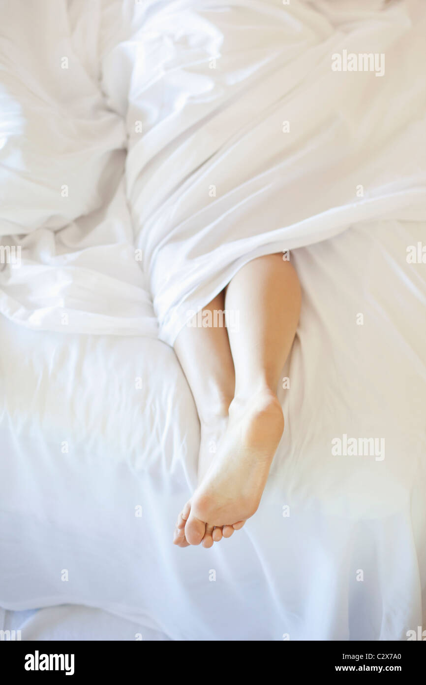 Frau die Füße im Bett Stockfoto