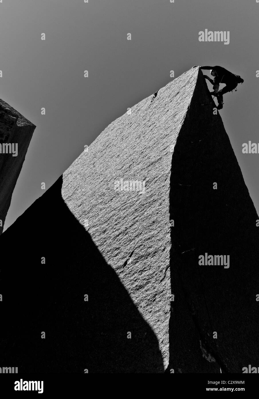 Männliche Felsen Kletterer kämpft für seinen nächsten Griff auf einem anspruchsvollen Aufstieg. Stockfoto