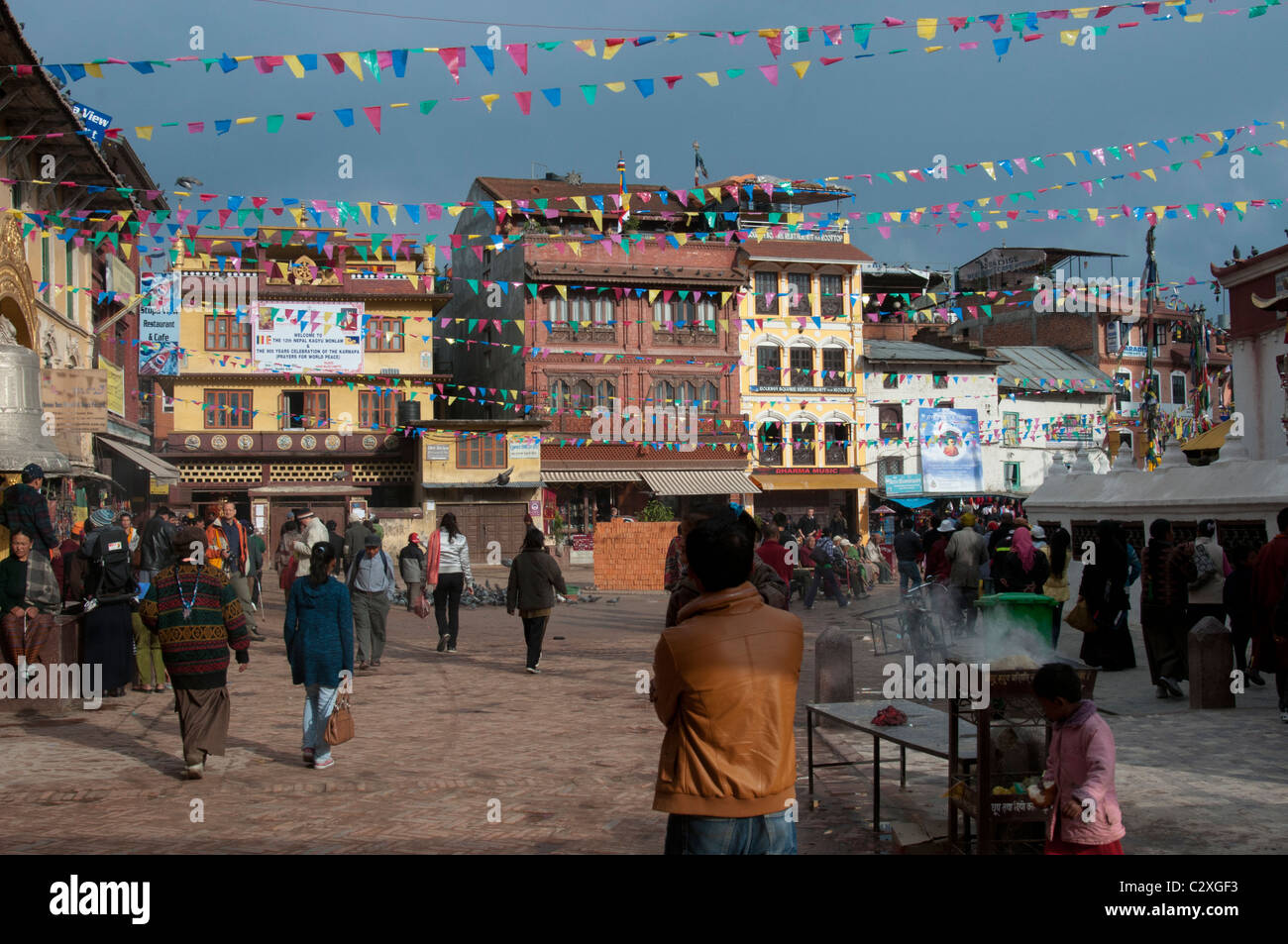 Gläubige kommen an einem der vielen tibetischen Klöster oder Gompas vorbei, die das große Boudha Stupa in der Nähe von Kathmandu, Nepal, umgeben Stockfoto
