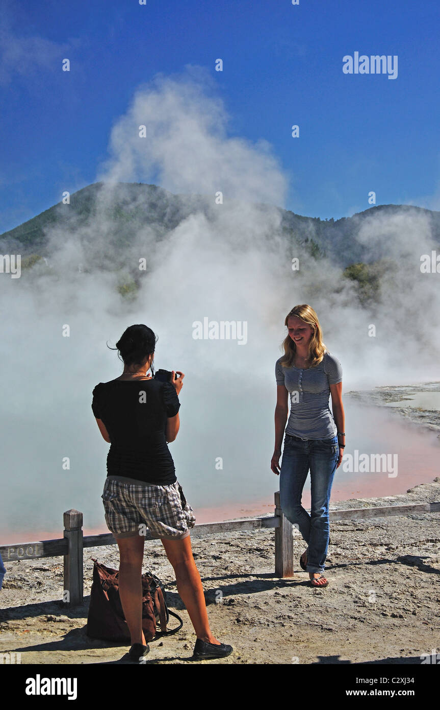 Junge Frauen fotografieren am Champagne Pool, Wai-O-Tapu Thermal Wonderland, Rotorua, Bay of Plenty Region, North Island, Neuseeland Stockfoto