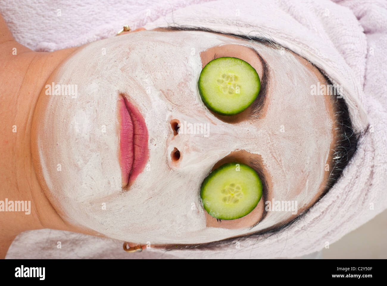 Detail der horizontal Kopfschuss Frau mit Gesichts-Maske und Scheiben Gurke auf Augen Stockfoto