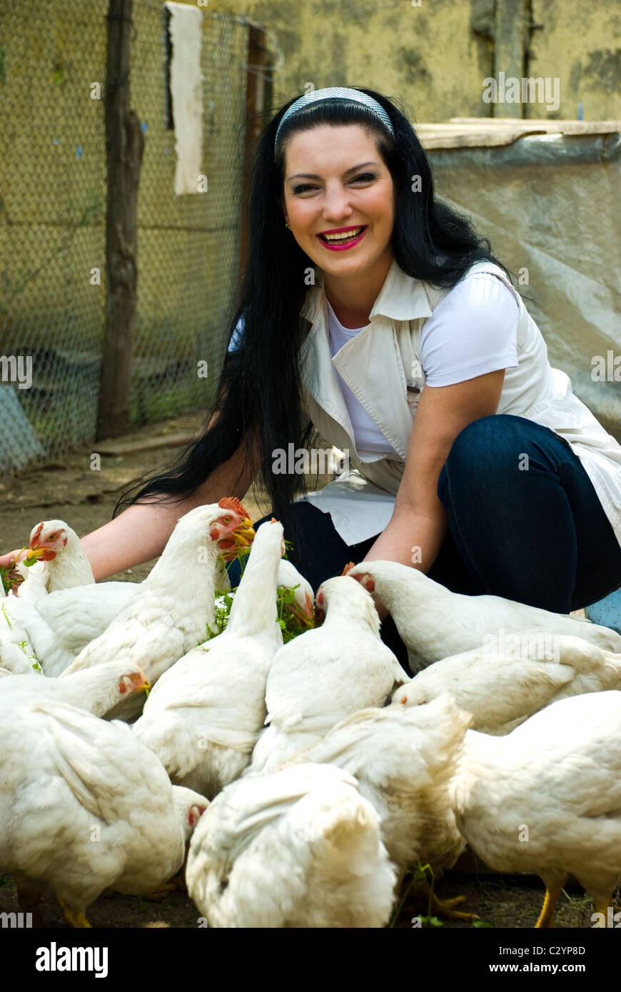 Lachende Frau großer Bauernhof Hühner füttern und Spaß Stockfoto