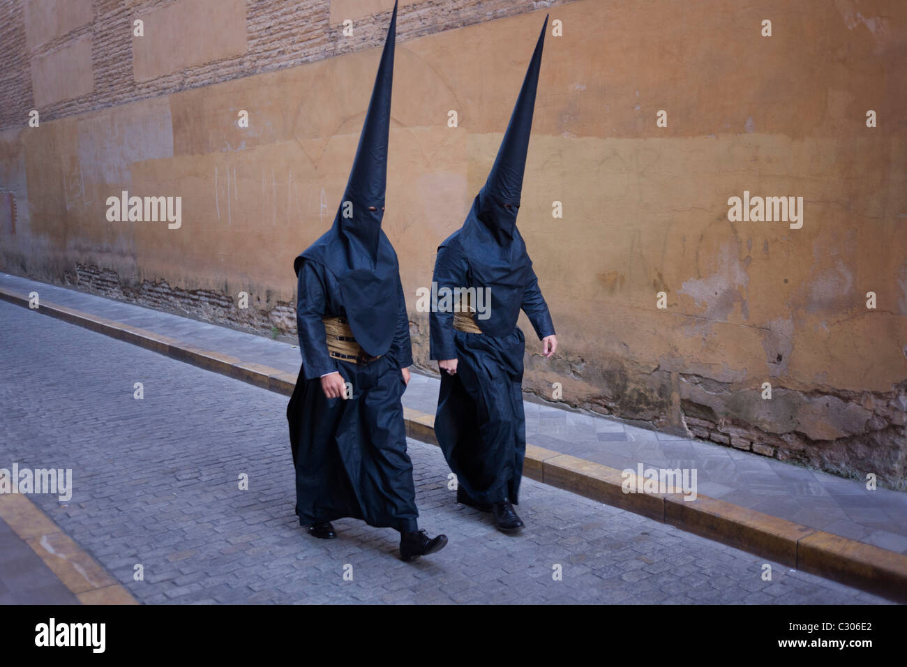 Mit Kapuze Büßer (Nazarenos) versammeln sich zum Sevillas jährliche Semana Santa Leidenschaft Osterprozessionen. Stockfoto