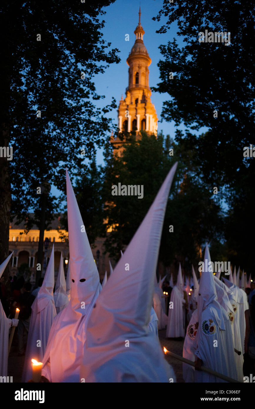 Mit Kapuze Büßer (Nazarenos) im Kerzenlicht-Prozession während Sevillas jährliche Karwoche (Semana Santa de Sevilla) Stockfoto