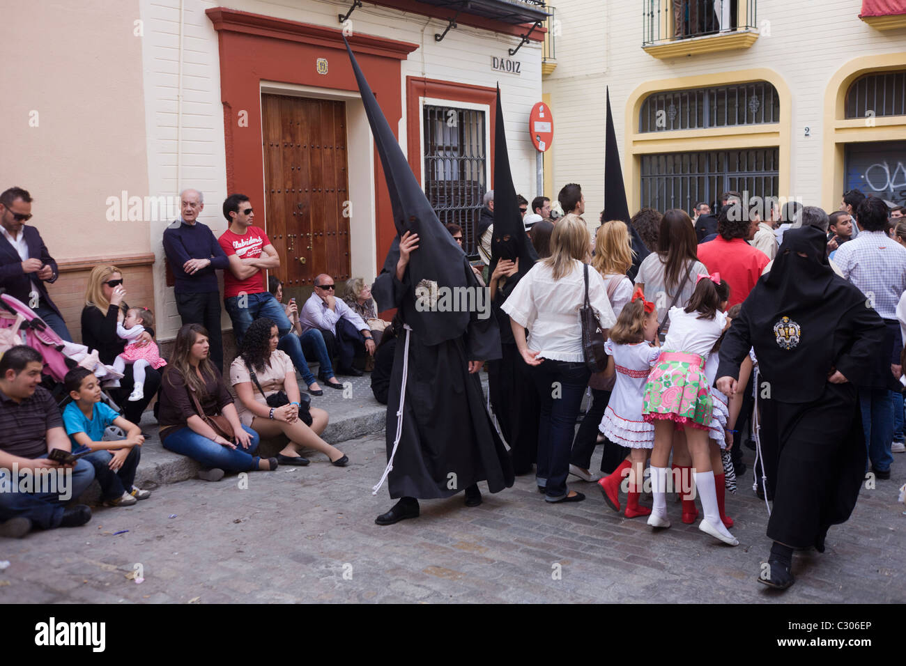 Mit Kapuze Büßer (Nazarenos) versammeln sich zum Sevillas jährliche Semana Santa Leidenschaft Osterprozessionen. Stockfoto