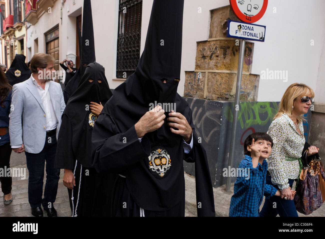 Mit Kapuze Büßer (Nazarenos) versammeln sich zum Sevillas jährliche Semana Santa Leidenschaft Osterprozessionen. Stockfoto