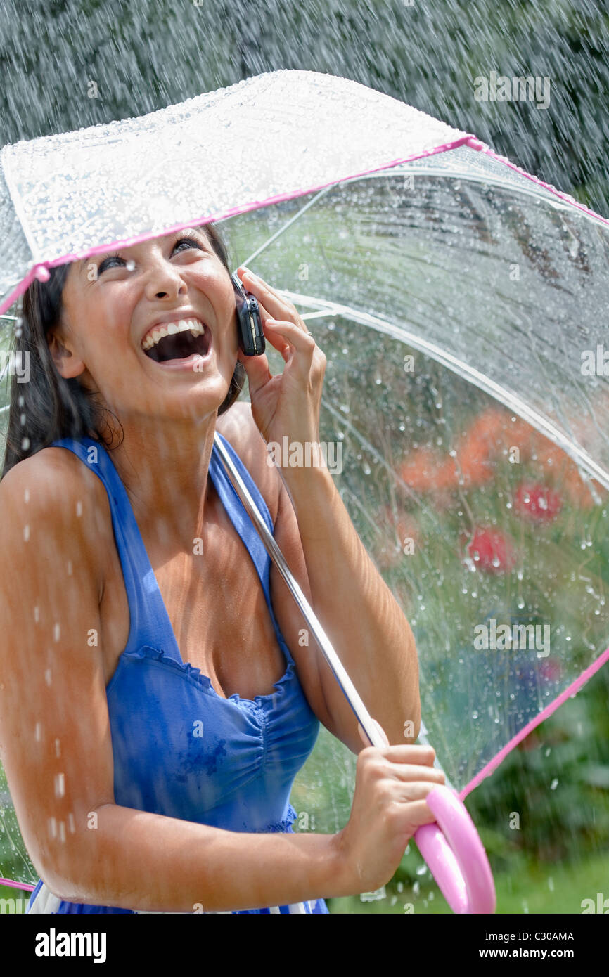 Asiatische Frau schöne Handy Regenschirm lachen Stockfoto