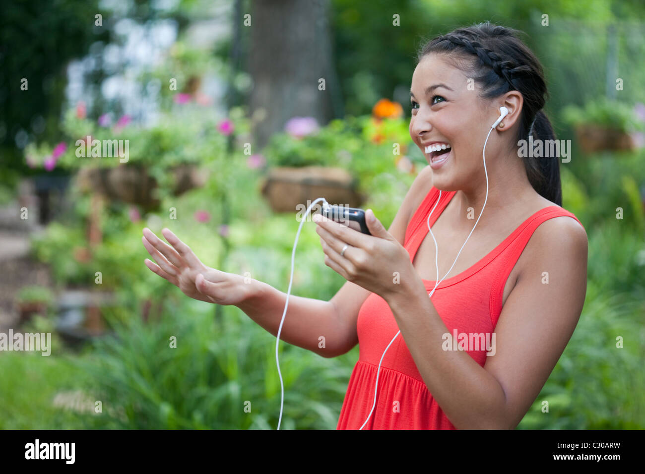 Attraktive junge asiatische Frau tanzt spielerisch Musik auf ihrem tragbaren Musik-Player. Horizontalen Schuss. Stockfoto