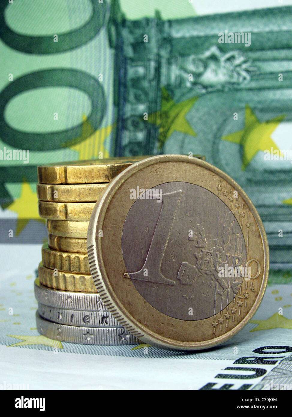 Haufen von Münzen liegen auf 100 Euro-banknote Stockfoto
