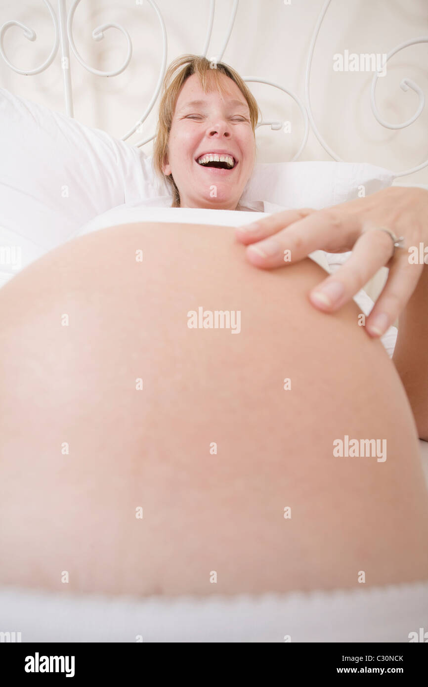 Schwangere Frau in high-Key lächelnd Stockfoto